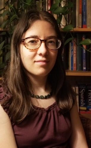 Photograph of Kristin Hoch sitting in front of a bookcase